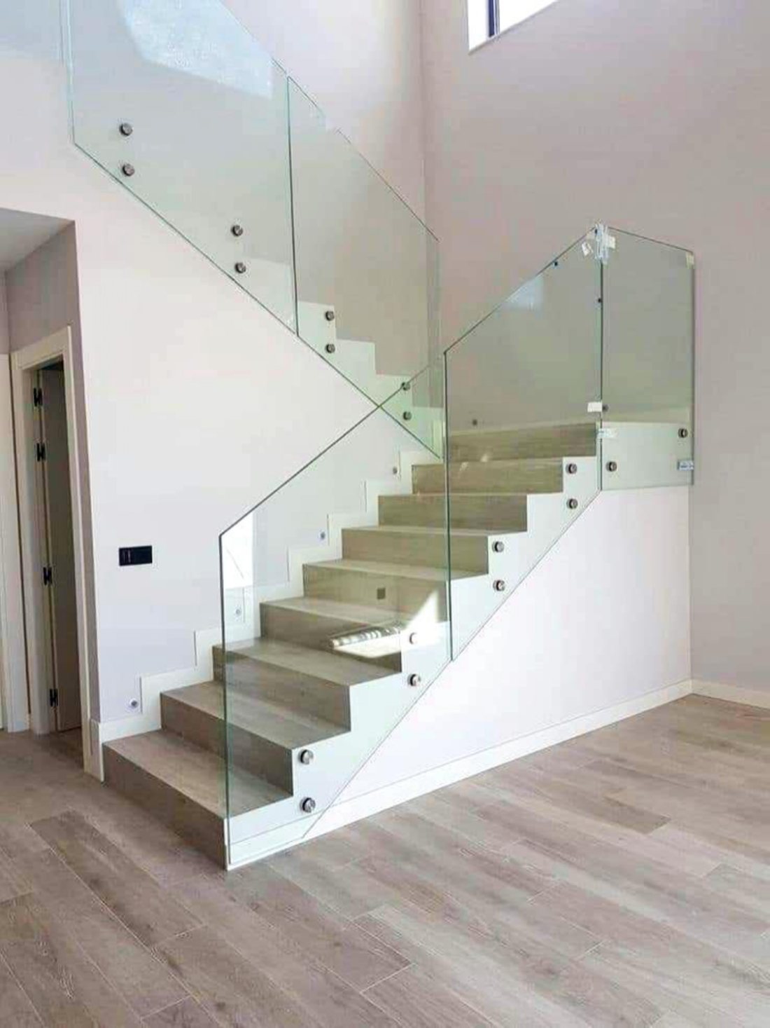 Frameless glass balustrade on floating wood stairs