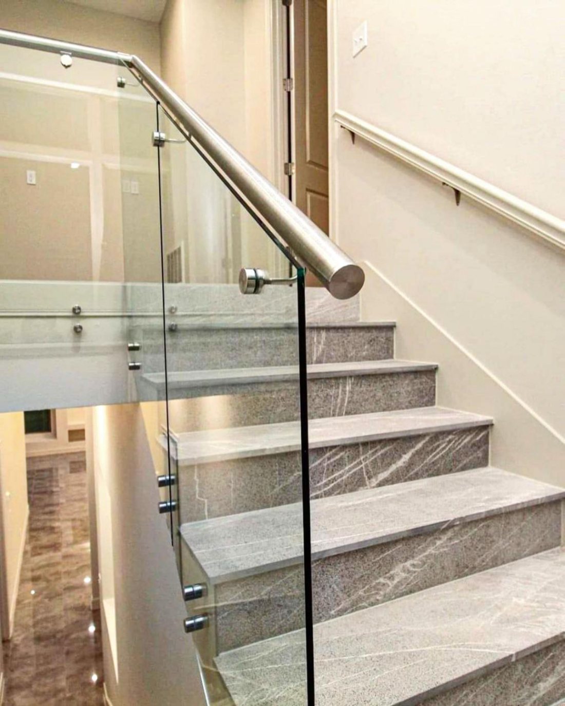 Frameless glass balustrade with stainless rail on marble stairs