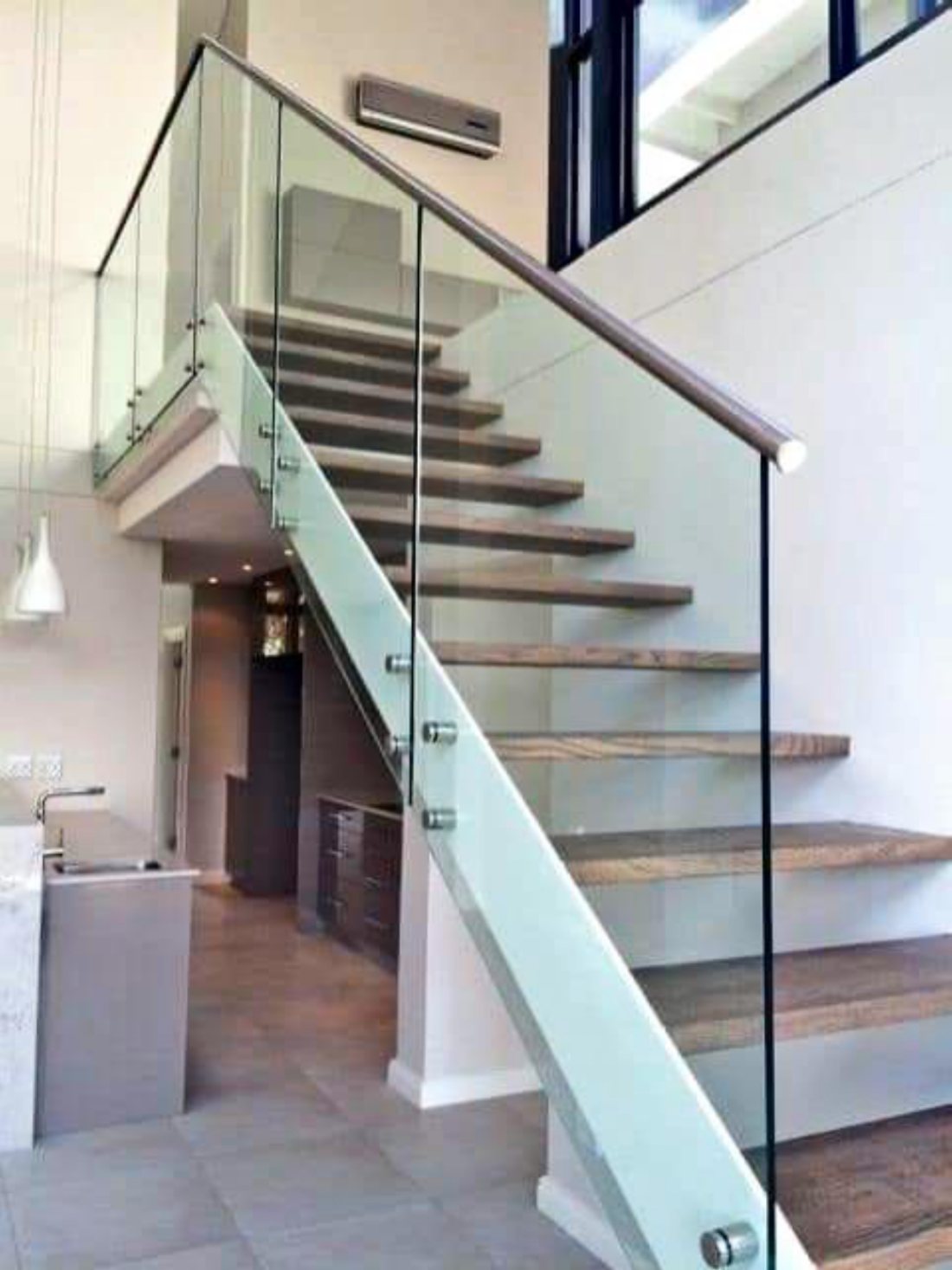 Glass balustrade on warm wood floating stairs