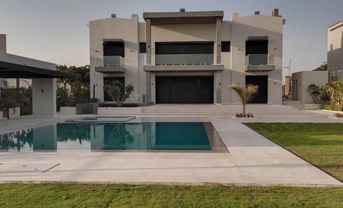 Roller shutters across a grand villa facade with pool