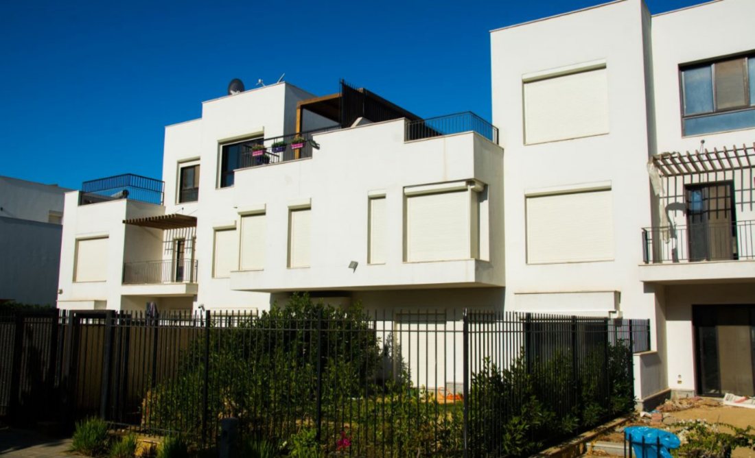 Closed roller shutters on a townhouse facade