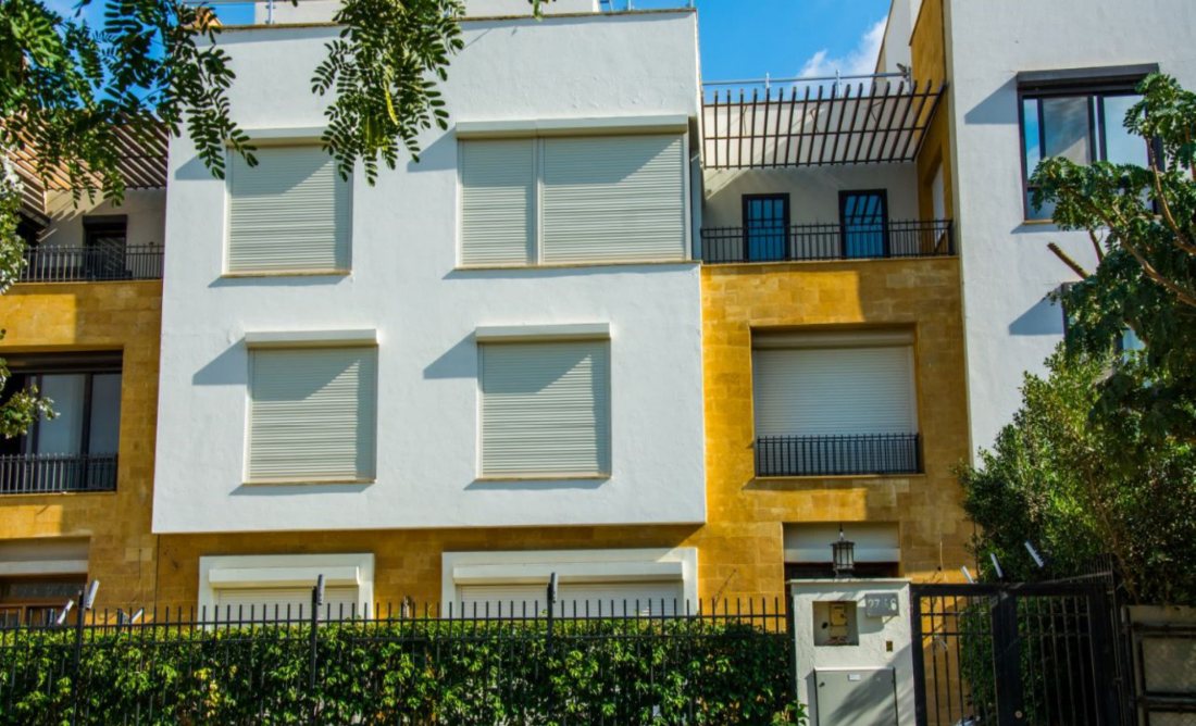 Roller shutters on a sandstone-clad villa