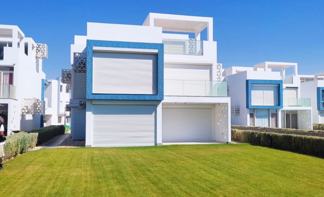 Large roller shutters on a blue-and-white beach villa