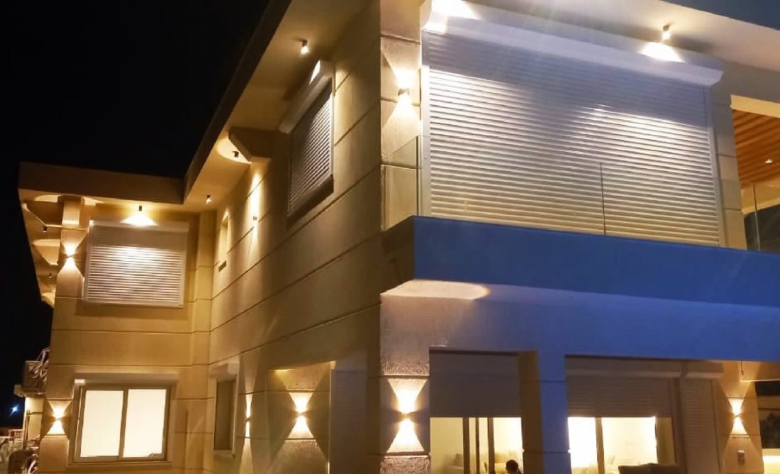 Illuminated roller shutters on a villa at night