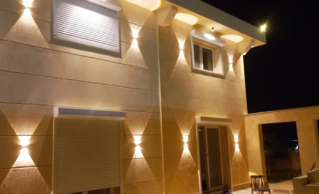 Roller shutter and window with facade lighting at night